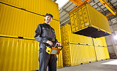 Mann steuert Kran in Containerlager Mann steuert Kran in Containerlager